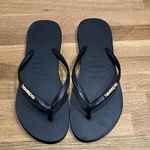 Havaianas Black Rubber Flip Flops w/ Gold Tone Trim 
Women’s 9/10
